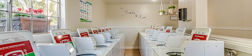 a laundry room with white washers and dryers