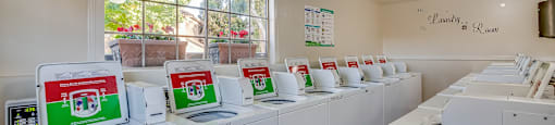 a laundry room with white washers and dryers