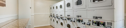 a washer and dryer room at the enclave at woodbridge apartments in sugar land,