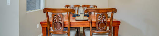 a dining room with a table and four chairs