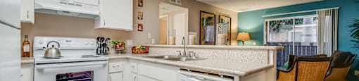 a kitchen with white cabinets and a white dishwasher