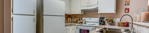 a kitchen with white cabinets and a granite counter top