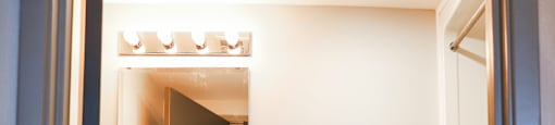 A white toilet sits in a bathroom next to a cabinet and a mirror.