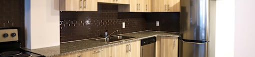 A kitchen with wooden cabinets and a black stove top oven.