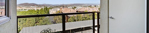 a balcony with a white door and a view of the city