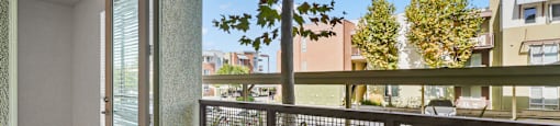 a balcony with a view of a yard and a tree