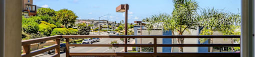 the view from the balcony of a condo overlooking a parking lot and a city