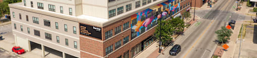 an aerial view of a brick and white building with a colorful mural on the side of it