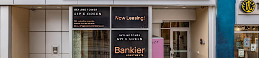 the facade of the skylite tower building with two signs in front of it