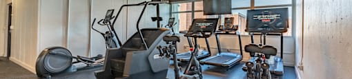 a workout room with weights and cardio equipment in a building