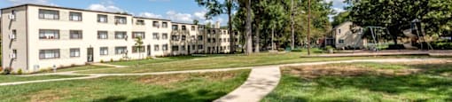 A sunny day at a residential area with apartment buildings and a walking path.