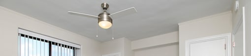 A room with a ceiling fan and two doors.