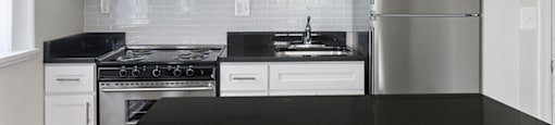 A kitchen with black countertops and white cabinets.