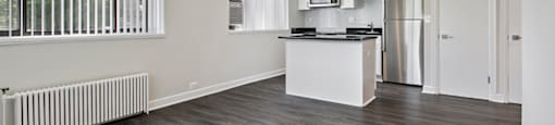 A spacious kitchen with a refrigerator, microwave, and oven.