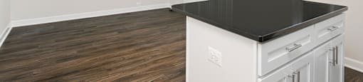 A kitchen with a black countertop and white cabinets.
