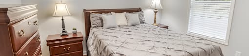 a bedroom with a bed and a dresser and a window