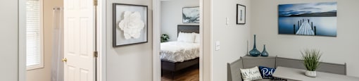 a living room with a desk and a bedroom with a bed