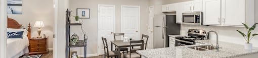 an open kitchen and living room with a dining room table and a kitchen counter top