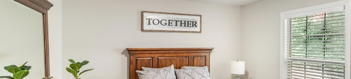 a bedroom with a bed and a dresser and a window