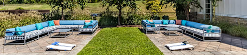 A large outdoor area with a grassy lawn and multiple lounge chairs.