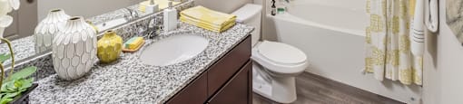 A bathroom with a white sink and a white toilet.