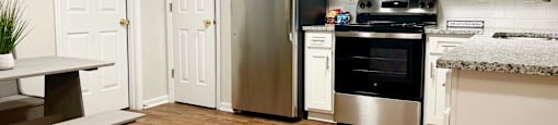 a kitchen with white cabinets and stainless steel appliances