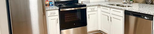 a kitchen with stainless steel appliances and white cabinets