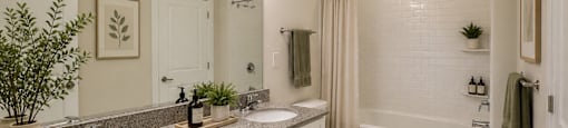 A bathroom with a toilet, sink, and bathtub.