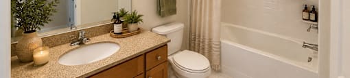 A bathroom with a sink, toilet, and bathtub.