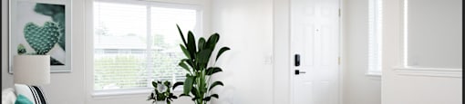 a living room with white walls and a green ottoman
