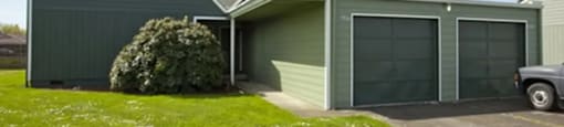 A grey house with a green lawn in front.