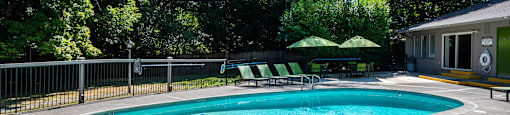 a resort style swimming pool in front of a house