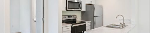 a kitchen with white cabinetry and stainless steel appliances