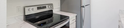 a kitchen with white cabinets and stainless steel appliances