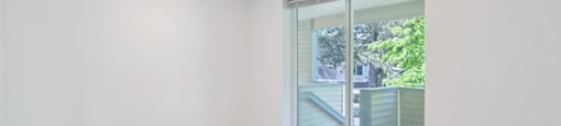 a bedroom with a large window and hardwood floors
