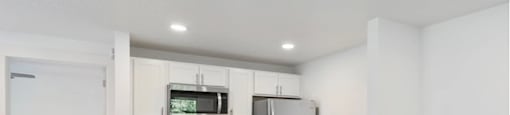 a kitchen with white walls and a wooden floor