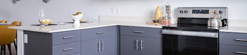a kitchen with gray cabinets and a white countertop