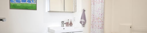 A white toilet sits next to a white sink in a bathroom.