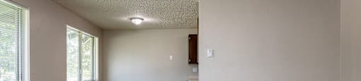 A room with a carpeted floor and a window.