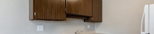 A kitchen with brown cabinets and a white stove.
