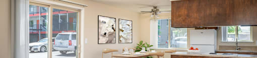the view of a living room and a kitchen with a table and chairs