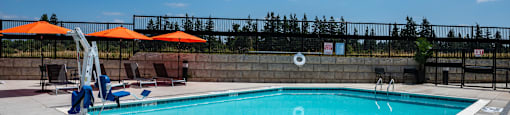 a swimming pool on a sunny day with umbrellas