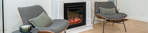 Two chairs are placed in front of a fireplace.
