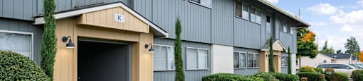 A building with a garage door entrance and a small porch area.