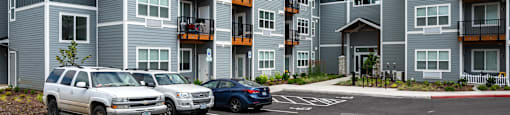 a large apartment building with a parking lot in front of it