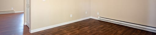 an empty living room with wood flooring and a door