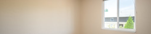 an empty room with carpet and a window