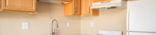 a kitchen with white appliances and wooden cabinets