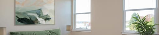 a bedroom with a green bed and two windows