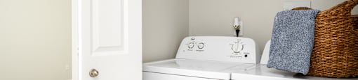 A white washing machine and dryer in a laundry room.